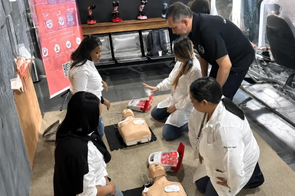 Turma praticando reanimação cardiopulmonar no treinamento presencial